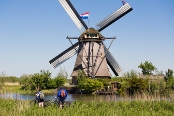 Couple with bikes watching the windmill at Kinderdijik