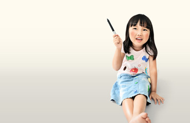 little asian girl smiling handle the pen and thinking acting on light yellow background with clipping path
