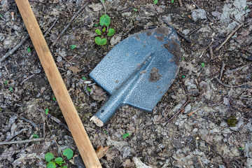 a broken new shovel on a forest ground next to the holder. The concept of unprofessional labor