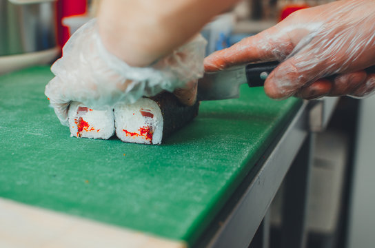 professional chef, chef the process of making sushi rolls, spins bamboo Mat and cut slices