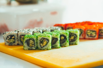 professional chef, chef the process of making sushi rolls, spins bamboo Mat and cut slices