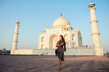 young girl tourist looking to the Taj Mahal in Agra, India . concept of culture, tourism and religion