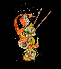 Foto auf Acrylglas Sushi-bar Fliegende Sushi-Stücke auf schwarzem Hintergrund