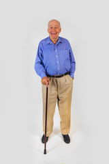 happy elderly man standing with his walking stick