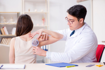 Doctor checking patients joint flexibility with gonimeter