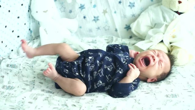 Baby boy crying lying in his bed