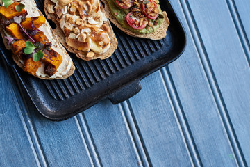 Delicious skillet made open faced sandwiches on a blue table
