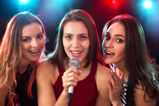 Girls having fun singing at a party