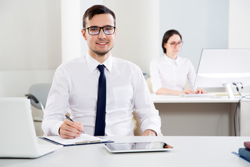 Obraz premium Young businessman smiling looking at camera