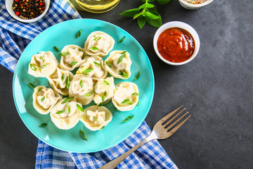 Homemade ready dumplings on a gray concrete table.