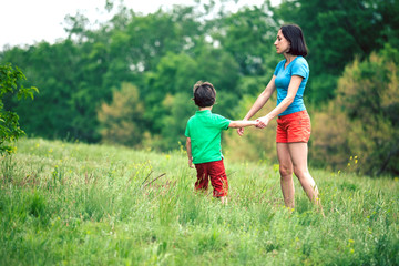 Fototapeta premium The boy walks with his mother in the meadow.