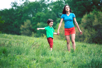 Fototapeta premium The boy walks with his mother in the meadow.