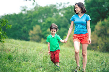 Fototapeta premium The boy walks with his mother in the meadow.