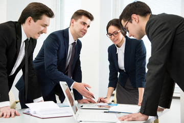 Business people are standing around a table
