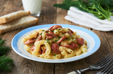 Pasta with sausages and dill on a plate