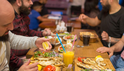 Group of people in restaurant enjoying Middle Eastern food. Selective focus
