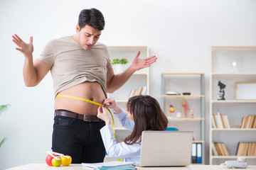 Doctor dietician giving advices to fat overweight patient