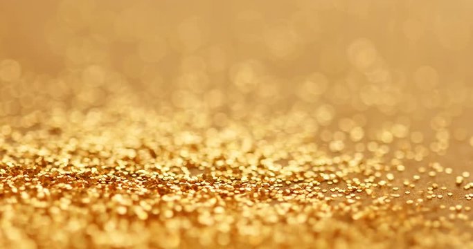 the luxury gold glitter sparkle shining falling on to the floor background , festival and celebration background concept , 4K Dci resolution