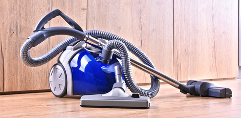 Canister vacuum cleaner for home use on the floor panels