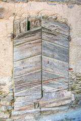 Eine in den Felsen eingelassenen ausgefranste Holztür