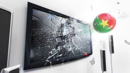 Soccer ball with the flag of Burkina Faso kicked through a shattering tv screen.(3D rendering series)