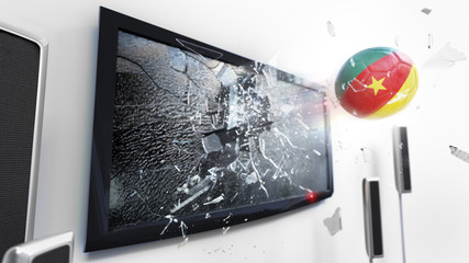 Soccer ball with the flag of Cameroon kicked through a shattering tv screen.(3D rendering series)