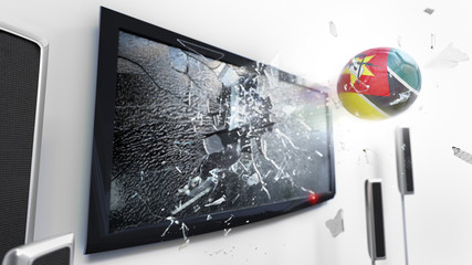 Soccer ball with the flag of Mozambique kicked through a shattering tv screen.(3D rendering series)