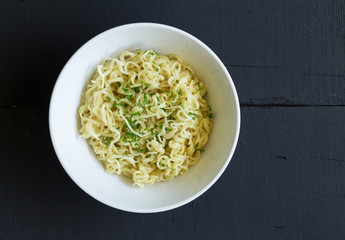 Bowl of egg noodles isolated on rustic black table - top view photo