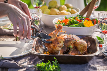 Sharing a chicken on table in the garden during dinner