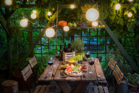 Garden table with appetizers and wine in summer evening