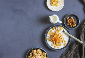 Breakfast selection preparation of muesli or cornflakes with dry fruits, nuts and jam.