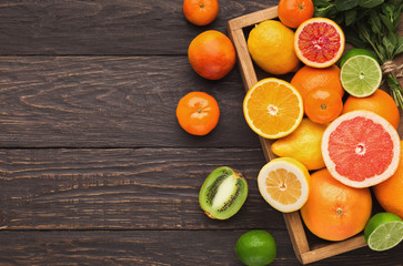 Variety of ripe citruses on wooden background