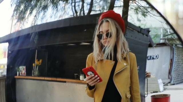 mirror reflection of young stylish woman using smart phone mobile outside bright colorful clothes sunglasses cool serious busy businesswoman internet surfing online communication 3G 4G connect