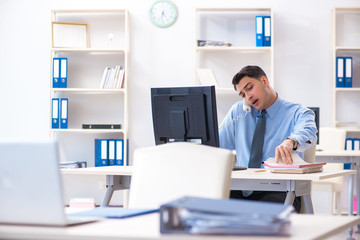 Handsome businessman employee sitting at his desk in office