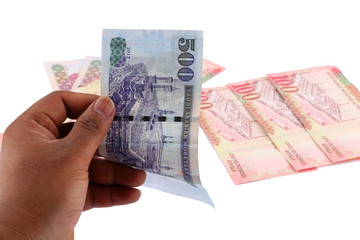 Saudi man counting thousands Saudi Riyal isolated on white background