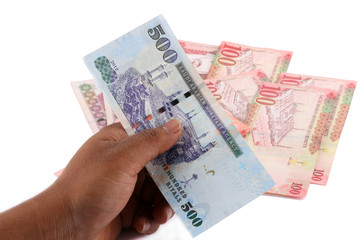 Saudi man counting thousands Saudi Riyal isolated on white background