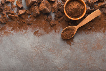 Crushed chocolate pieces on gray background, top view