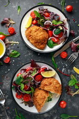 Breaded Chicken Kiev breast stuffed with butter, garlic and herbs served with vegetables in a plate.
