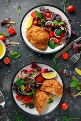  Breaded Chicken Kiev breast stuffed with butter, garlic and herbs served with vegetables in a plate. © grinchh