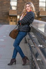 The girl is standing near the handrail