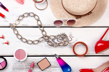 Obraz na płótnie Canvas Feminine beauty background, top view. Shoes, sunglasses, hat and makeup essentials. Women fashion accessories.