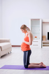 Fototapeta na wymiar Pregnant woman doing sport exercise at home