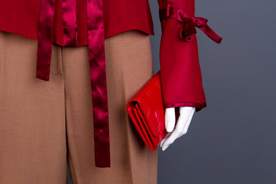 Close up mannequin with red purse. Dummy with stylish women shirt, trousers and wallet, copy space. Feminine elegance and fashion.