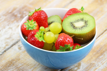 Bowl full of fresh fruit: strawberries, kiwi and grapes
