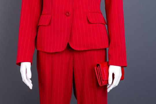 Formal style red suit and wallet. Female mannequin in elegant business style suit, cropped image. Feminine fashionable outfit.
