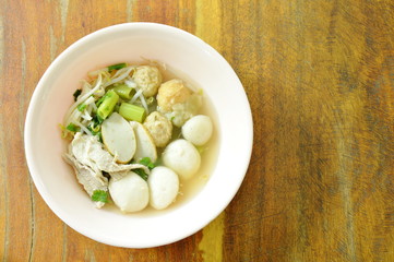 boiled fish and shrimp ball topping slice pork in clear soup on bowl