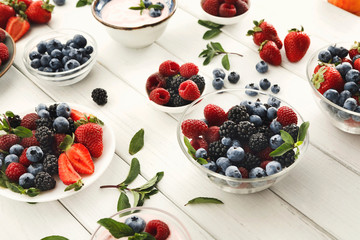 Healthy breakfast with berries and yogurt on white wooden table