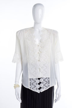 White lace blouse for women. Female mannequin clothed in satin shirt and black skirt. Feminine elegance and style.