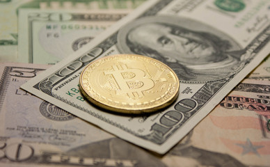 golden bitcoin coin on us dollars close up