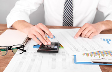 Businessman analizing summary report and reviewing accounting data and calculate order income.